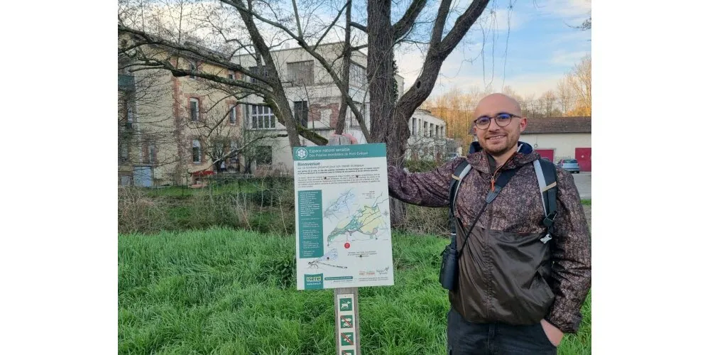 Fabrice devant un panneau pédagogique d'un espace naturel